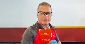 Técnico de Carglass con una tarjeta de voluntario solidario